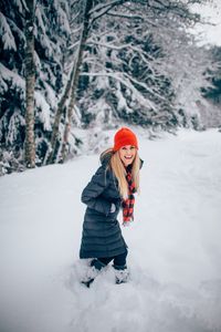 Portrait of happy woman on snow covered field
