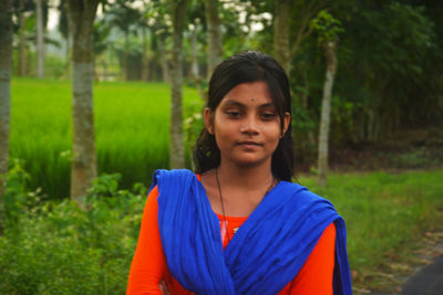 Portrait of beautiful young woman standing on land