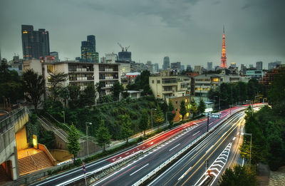 High angle view of light trails on road amidst buildings in city