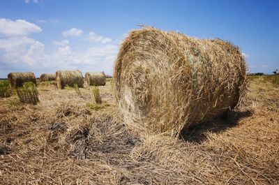 Hay bales on field against sky