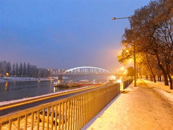 Illuminated bridge against clear sky at night