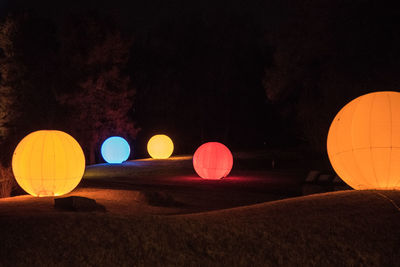 Hot air balloon against trees at night
