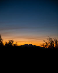 Silhouette trees against sky during sunset
