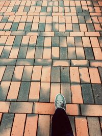 Low section of man standing on cobblestone street