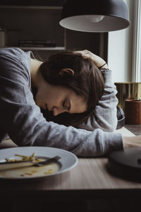 Side view of sad woman at table