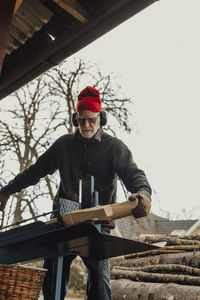 Senior man sawing wood