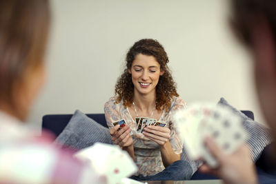 Beautiful woman smiling while playing cards with friends