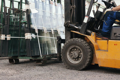 Worker driving forklift and loading glass constructions