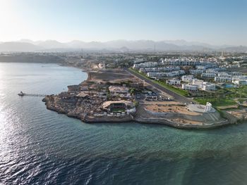 High angle view of townscape by sea against sky