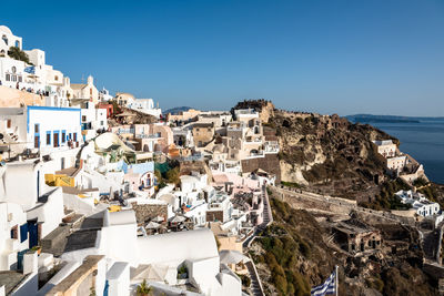 Town by sea against clear blue sky