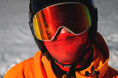 Portrait of a snowboarder. ski goggles and ski helmet on a man looking at the camera, close-up