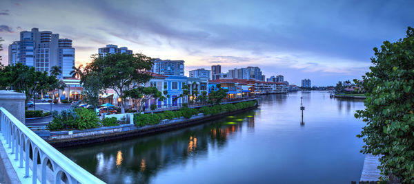 River amidst buildings in city against sky