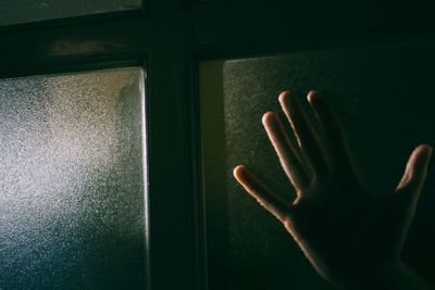 Close-up of hand on window