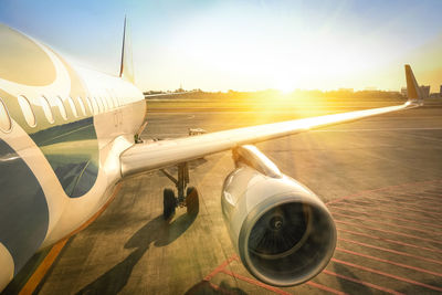 Airplane on airport runway against sky