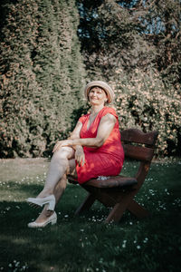 Portrait of mature woman sitting on bench at park