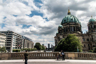 People in city against cloudy sky