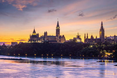 View of historical buildings river during sunset