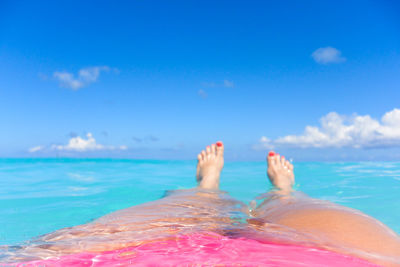 Low section of man relaxing in swimming pool