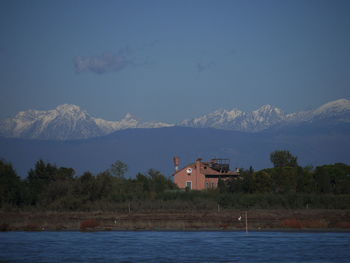 Buildings by sea against sky