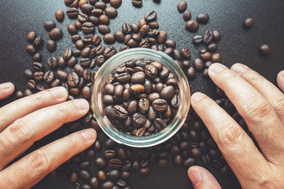 High angle view of hand holding coffee beans