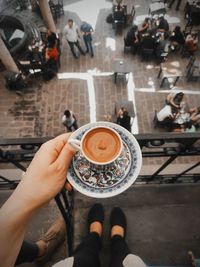 Low section of woman holding coffee cup