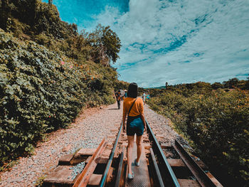 Rear view of man standing on railroad track