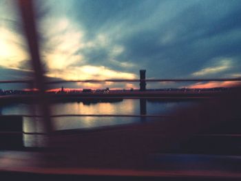 Bridge against cloudy sky at sunset