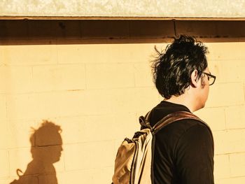 Rear view of man standing against wall