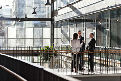 Male and female business professionals planning while standing in office lobby