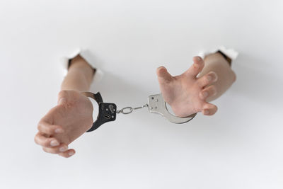 Close-up of hand holding hands over white background