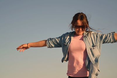 Young woman against blue sky