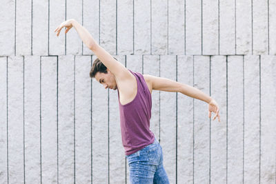 Full length of woman standing against wall