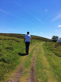 Man walking on field against clear sky