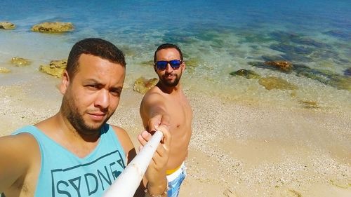 Portrait of happy friends standing at beach