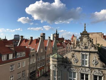 Buildings in city against cloudy sky