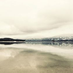 Scenic view of lake against sky during winter