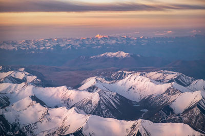 Scenic view of snowcapped mountains against sky during sunset