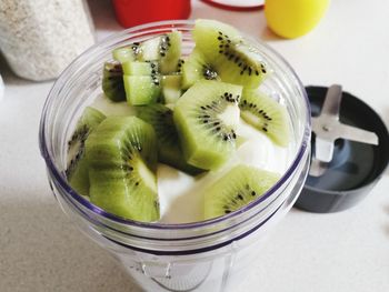 High angle view of kiwi and fruits in container on table