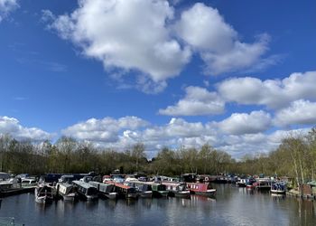 Boats moored in river against sky