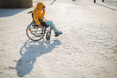 Low section of man riding bicycle on snow