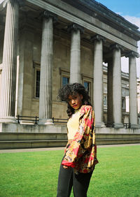 Portrait of smiling woman standing against building