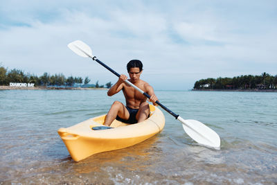 Man kayaking in sea