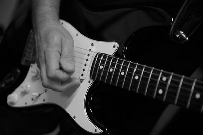 Midsection of man playing guitar