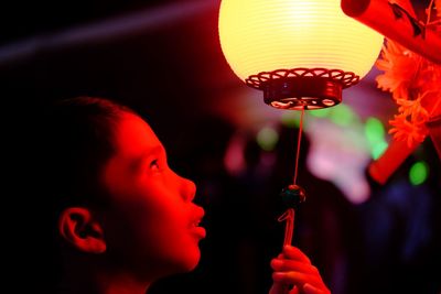 Close-up portrait of a boy holding lantern