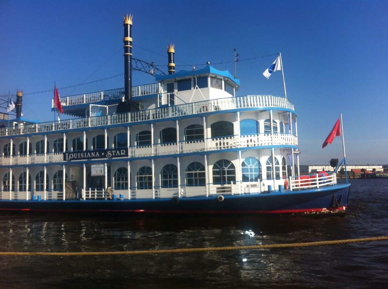 nautical vessel, water, transportation, boat, mode of transport, waterfront, moored, clear sky, built structure, architecture, sea, blue, building exterior, travel, sky, rippled, day, reflection, outdoors, river