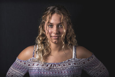 Portrait of beautiful young woman over black background