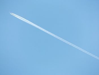 Low angle view of helicopter against clear blue sky