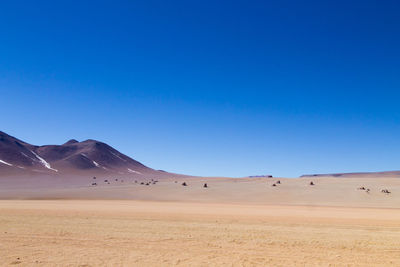 Scenic view of desert against clear blue sky