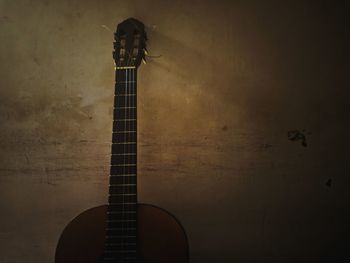 Low angle view of guitar against wall