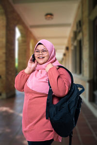 Young woman talking on phone in corridor